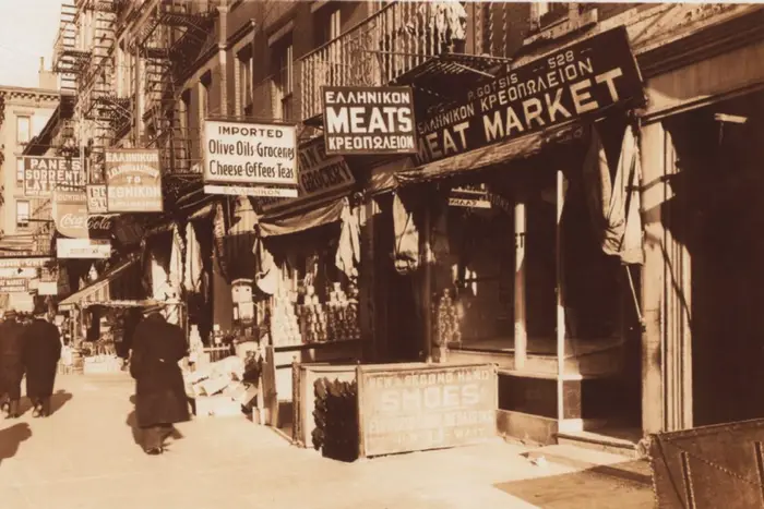 Black and white photograph showing old storefront from hanging signs